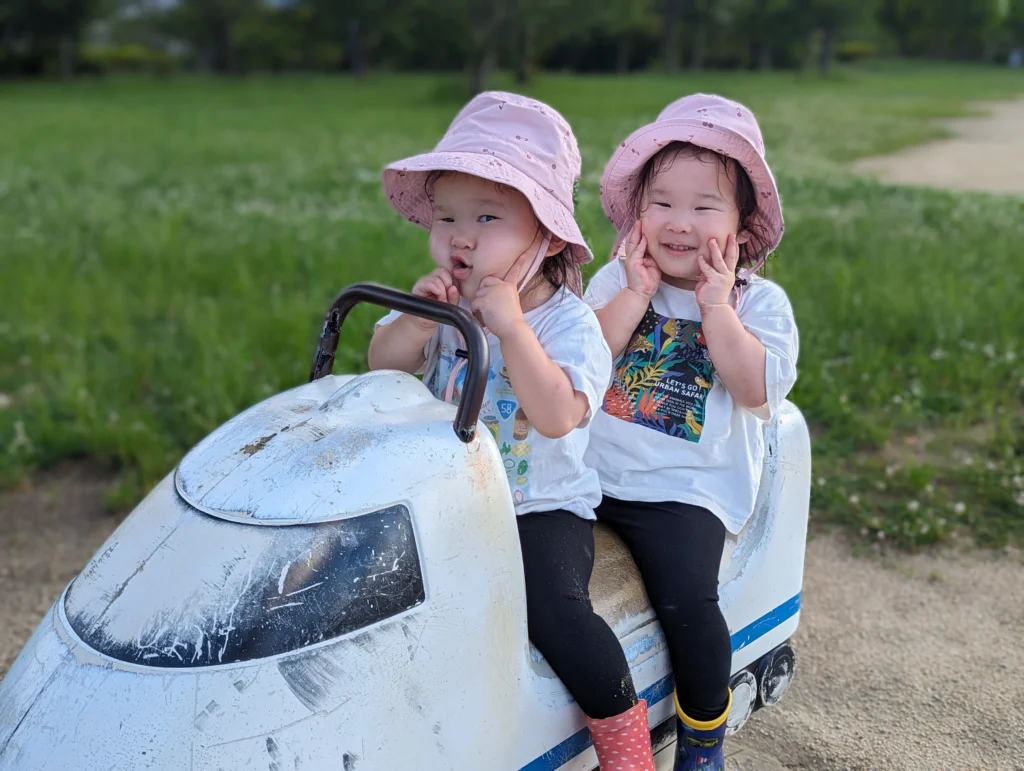 公園の遊具で遊ぶ双子の女の子