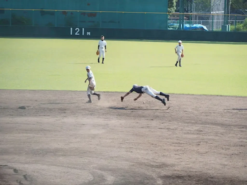 打球をダイビングキャッチする野球選手