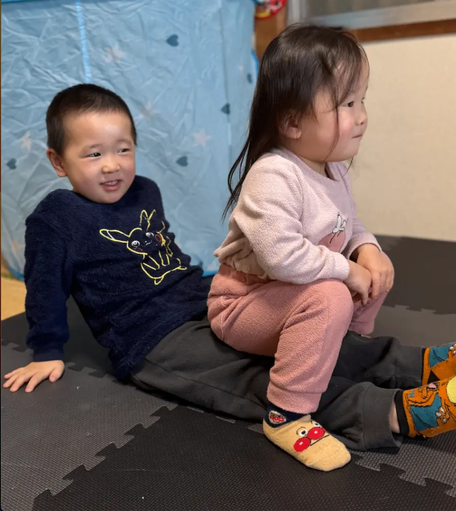 兄の足の上に座っている妹